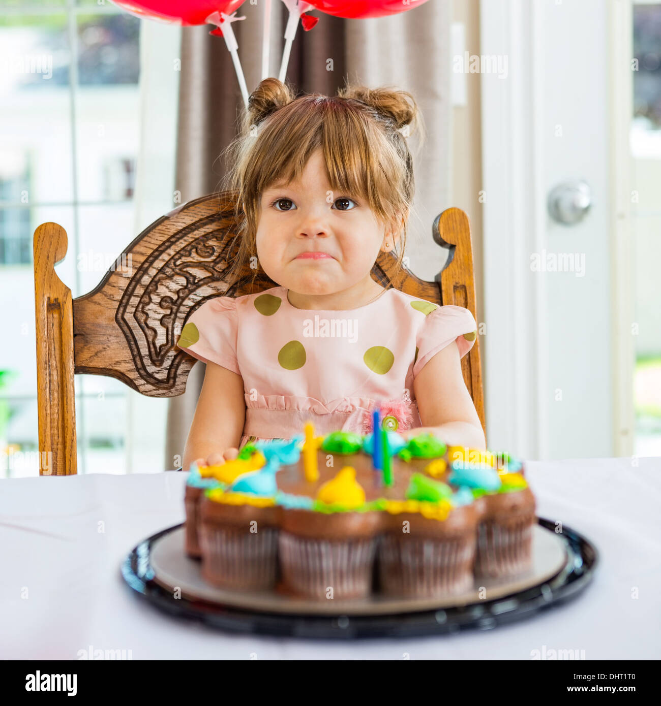 Anniversaire fille assise en face de gâteau Banque D'Images