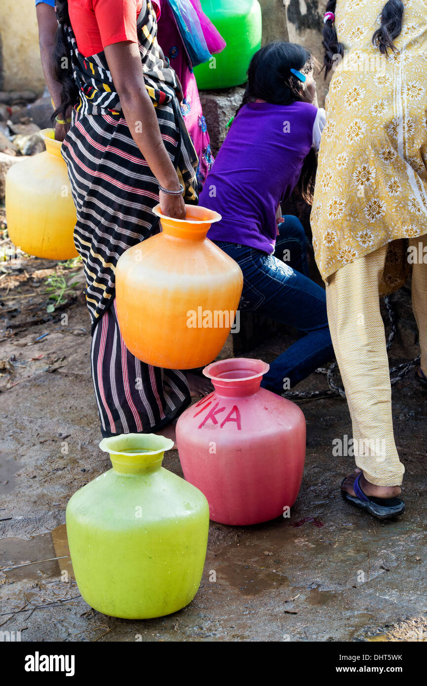 Les pots en plastique et indienne et les filles à un puits dans un village de l'Inde rurale street. L'Andhra Pradesh, Inde Banque D'Images