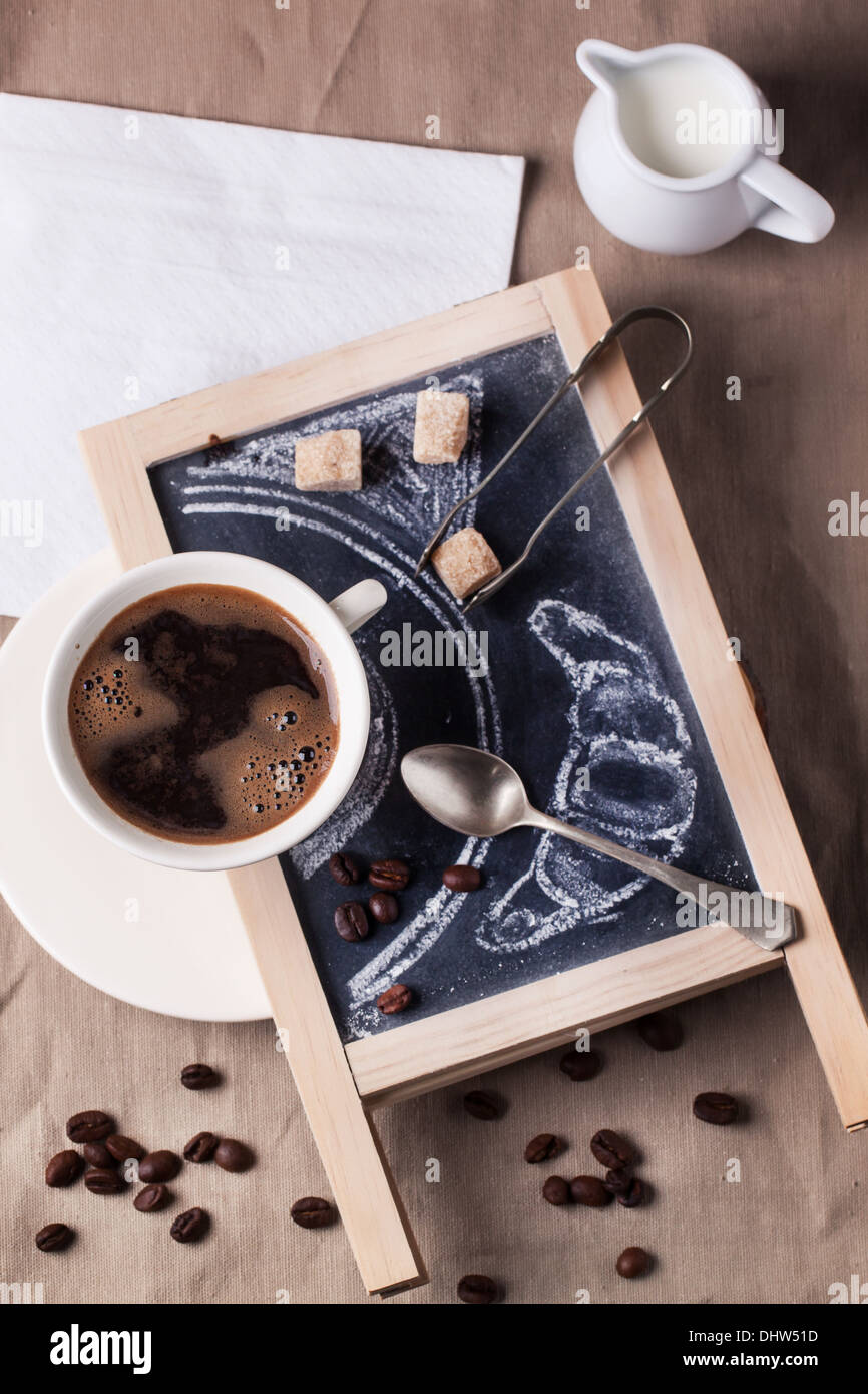 Vue supérieure de la tasse de café sur le tableau sur le sucre, cuillère et le croissant peint nappe textile. Voir la série Banque D'Images