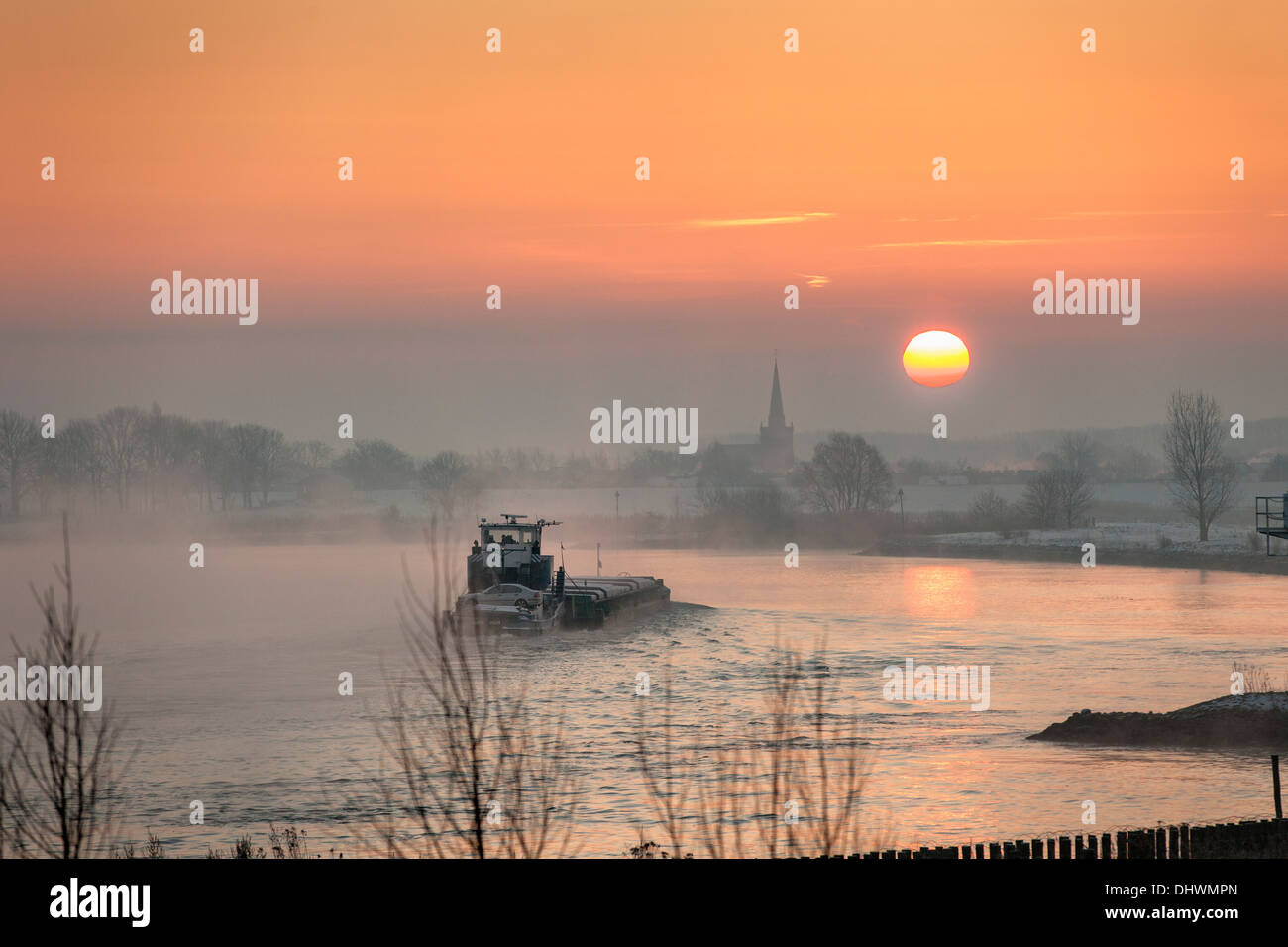 Pays-bas, Lopik, toits de village près de la rivière Lek. Inland barge cargo. Le lever du soleil. L'hiver Banque D'Images