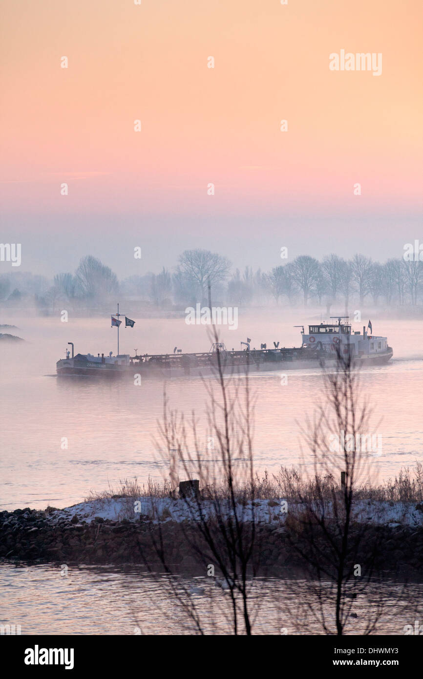 Pays-bas, Lopik, Lek river. Inland barge cargo. Le lever du soleil. L'hiver Banque D'Images
