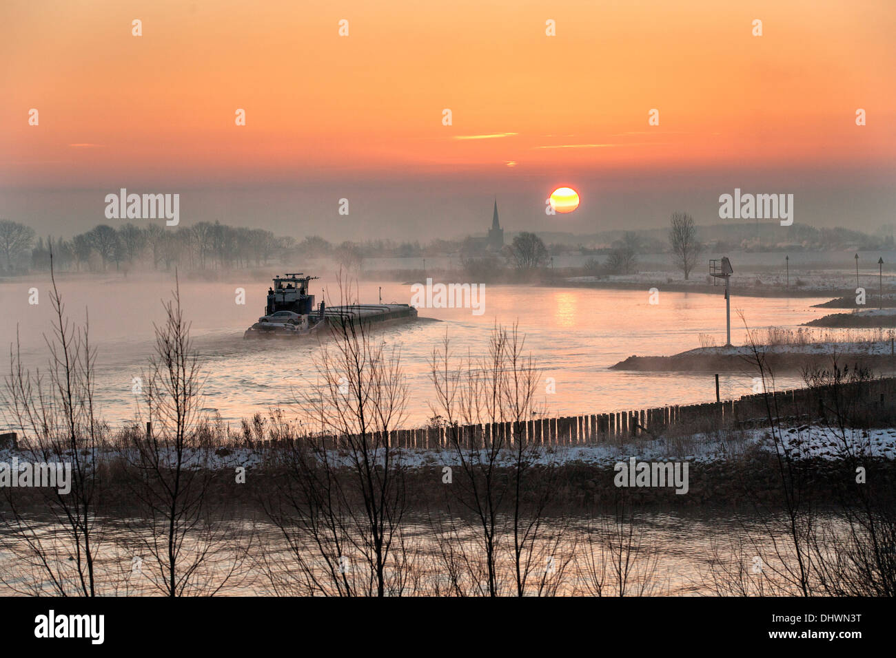Pays-bas, Lopik, toits de village près de la rivière Lek. Inland barge cargo. Le lever du soleil. L'hiver Banque D'Images