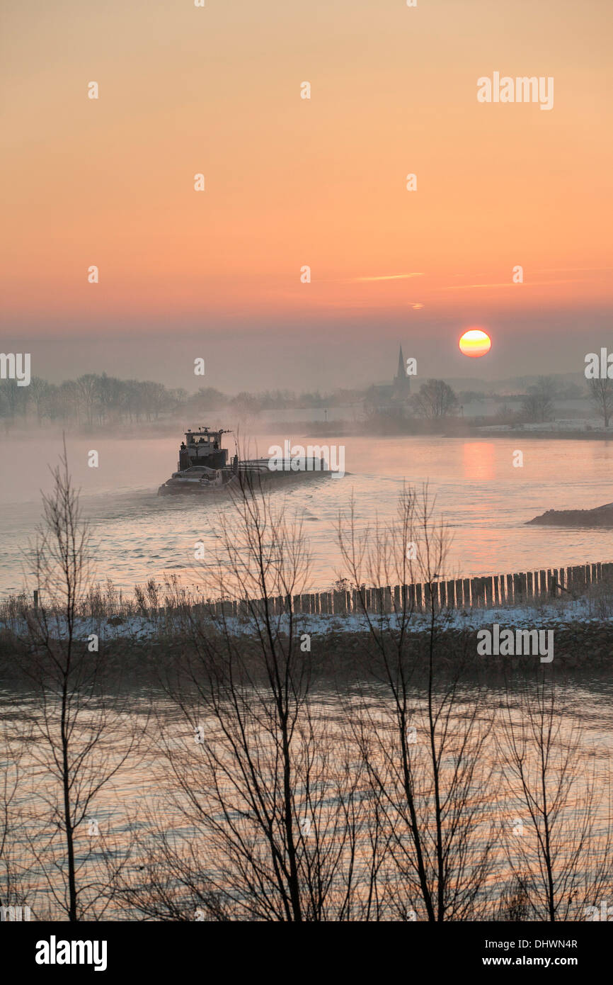 Pays-bas, Lopik, toits de village près de la rivière Lek. Inland barge cargo. Le lever du soleil. L'hiver Banque D'Images