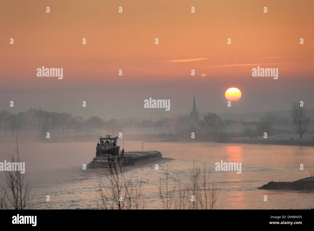 Pays-bas, Lopik, toits de village près de la rivière Lek. Inland barge cargo. Le lever du soleil. L'hiver Banque D'Images