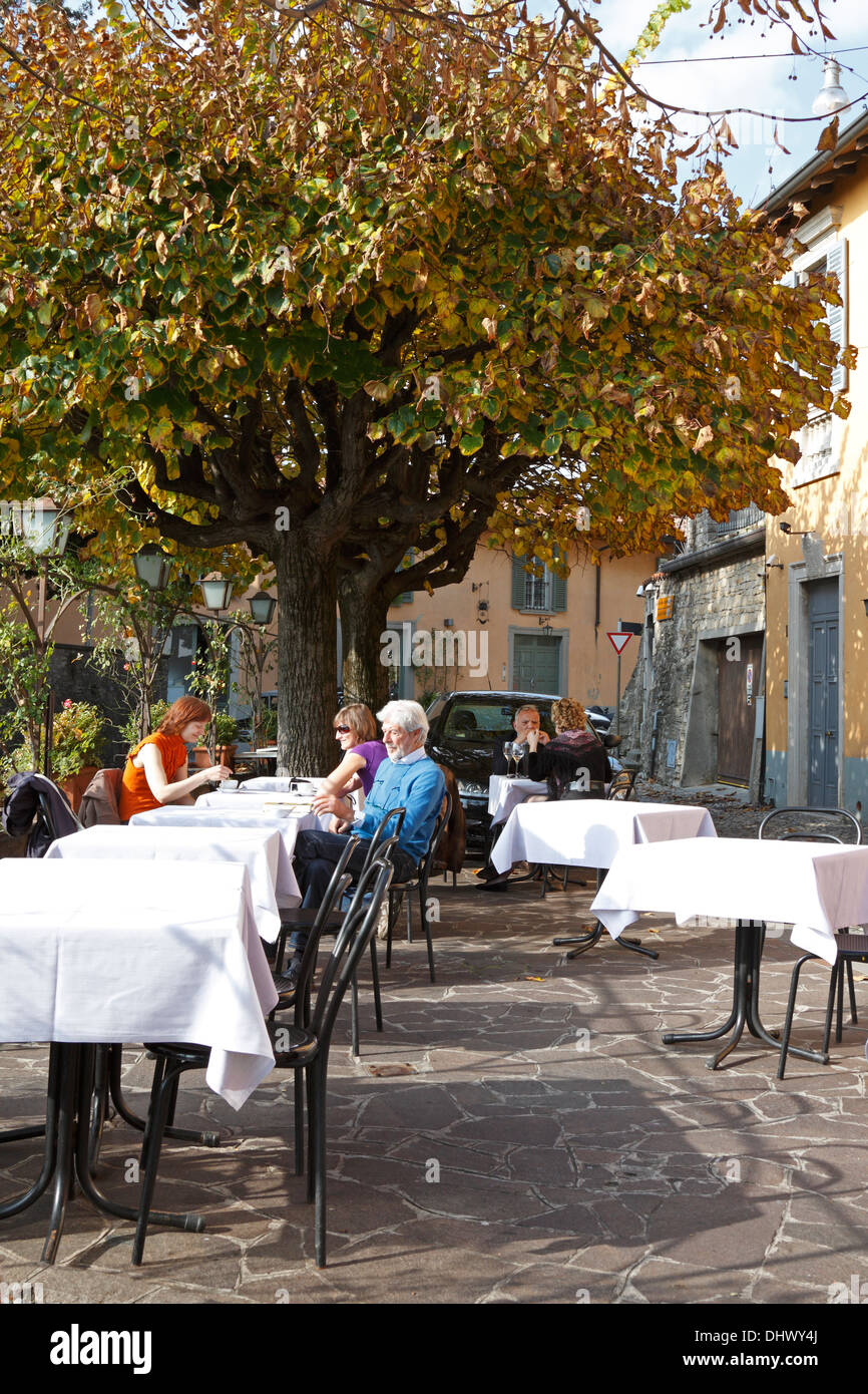 Les Italiens s'assit à table pour avoir des boissons à l'extérieur du restaurant Baretto di L. Vigilio dans Bergamo Alta, l'Italie. Banque D'Images