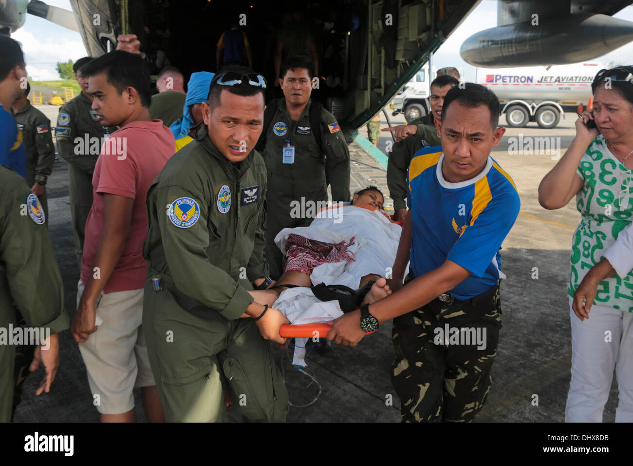 Les Marines américains et les Forces armées des Philippines aviateurs transporter un blessé évacué de Tacloban aux installations médicales, le 14 novembre 2013 à Villamor Air Base, Manille, Philippines. Les sinistrés continuent d'être transportés à Manille au lendemain de super typhon Haiyan. Banque D'Images