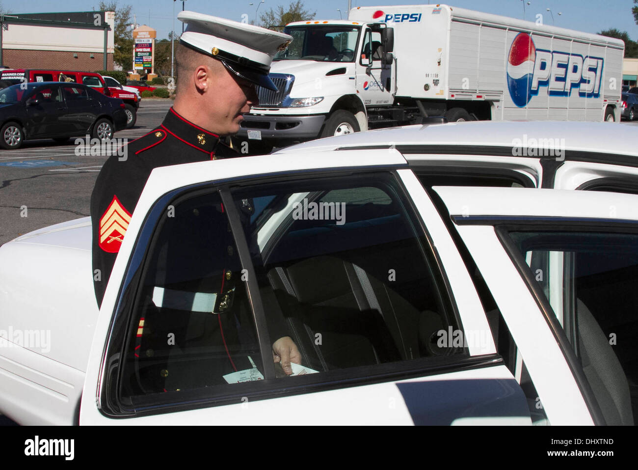 Le sergent du Corps des Marines des États-Unis. Bryan Jeffers, un recruteur avec le recrutement du Corps des marines sous-station Aberdeen et Jacksonville, en Floride, les autochtones, entre dans un véhicule de l'adjoint du shérif dans le cadre de l'Pinehurst-Southern Pines Muscular Dystrophy Association Lock- Banque D'Images