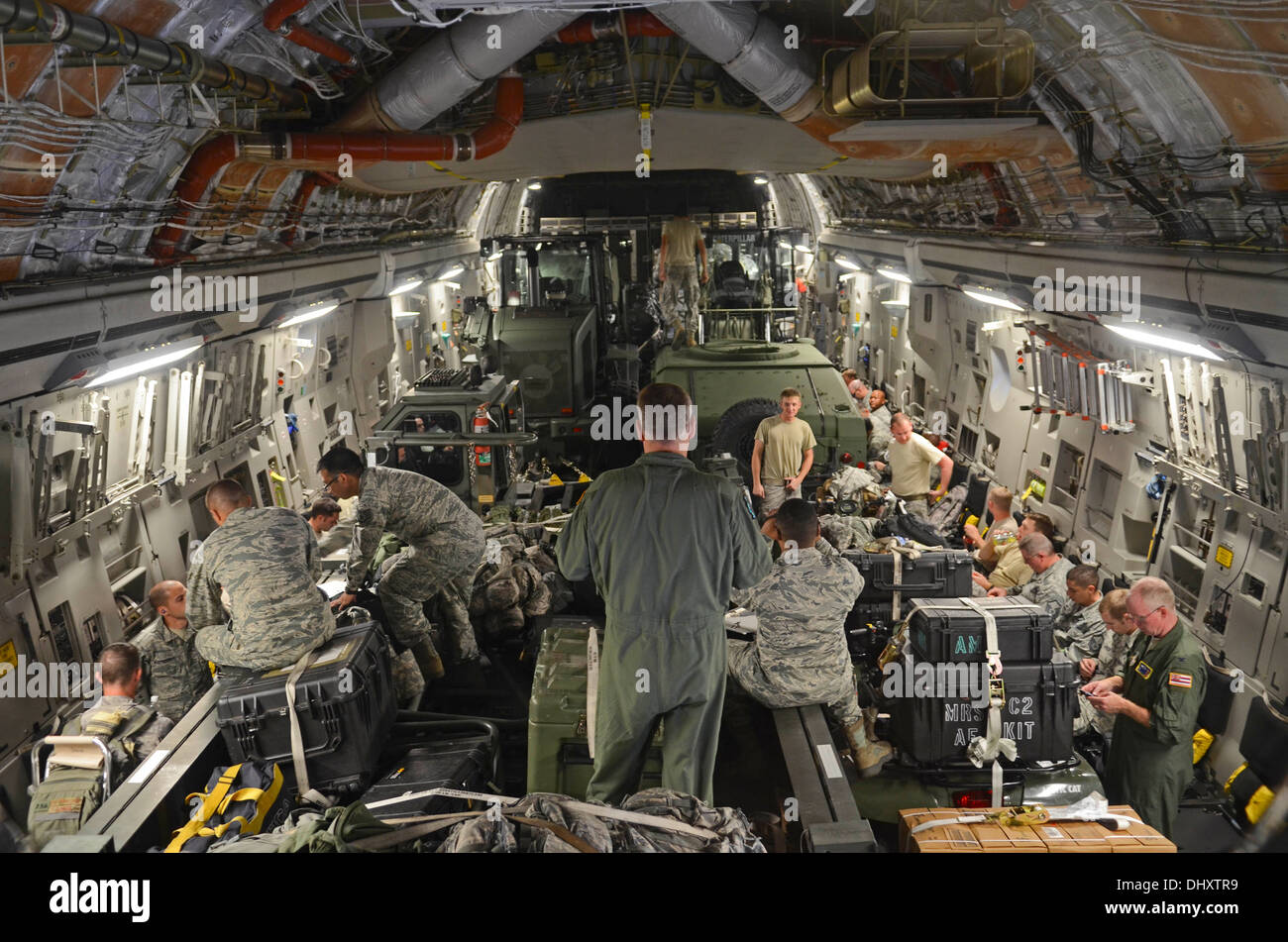 Aviateurs de la 36e Groupe d'intervention d'urgence et 535e Escadron de transport aérien situer leurs bagages eux-mêmes et sur leurs sièges le 15 novembre 2013, sur l'Andersen Air Force Base, Guam, flightline avant le départ de l'aéronef pour appuyer l'opération à Damayan Tacl Banque D'Images