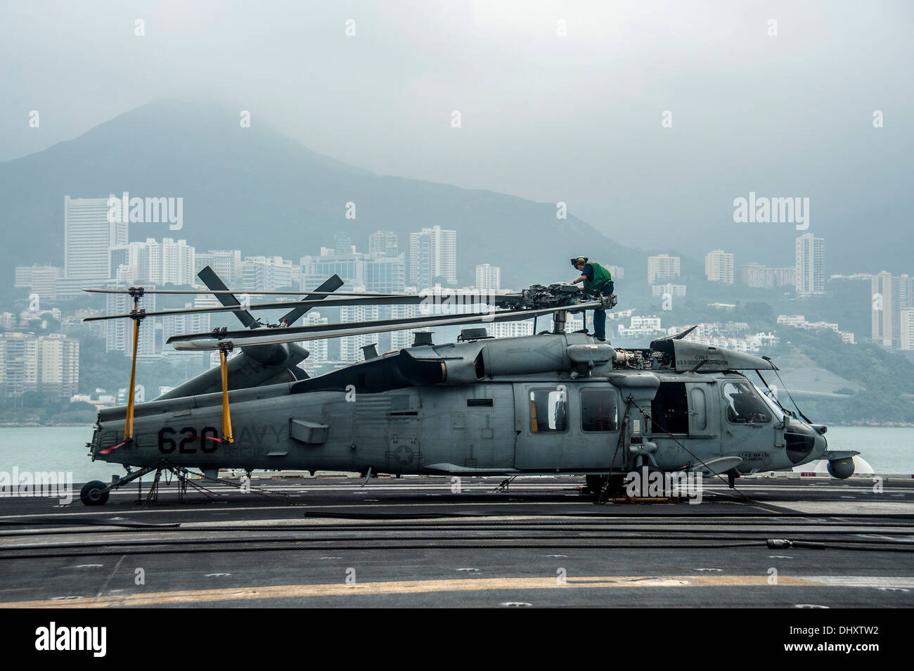 HONG KONG (nov. 12, 2013) l'Aviation Machiniste 4400 2e classe Vasya Mstislavski, de Phoenix, s'occupe de l'entretien sur le rotor d'un MH-60S Seahawk de la 'Golden Falcon' de la mer d'hélicoptères de l'Escadron de Combat (HSC) 12 dans le poste de pilotage de la Marine américaine' Banque D'Images