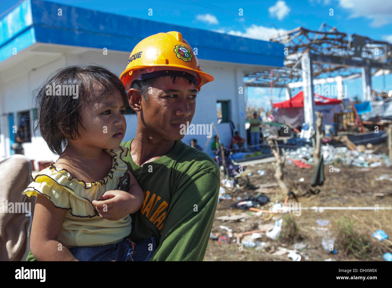 Un soldat de sauvetage de l'armée philippine est titulaire d'un enfant philippin en attendant de charger sur un avion pour le transport à Manille au Tacl Banque D'Images