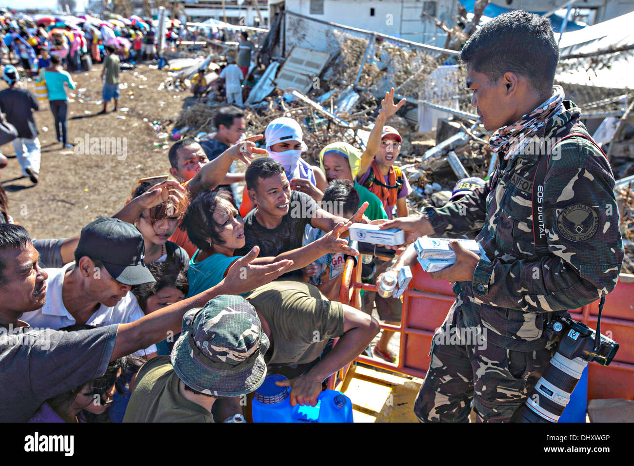 Un soldat de l'Armée Philippine distribue une aide alimentaire aux personnes déplacées par le typhon Haiyan en attente d'un avion pour l'évacuation à Manille le 15 novembre 2013 à la base aérienne de Tacloban, Philippines. Banque D'Images