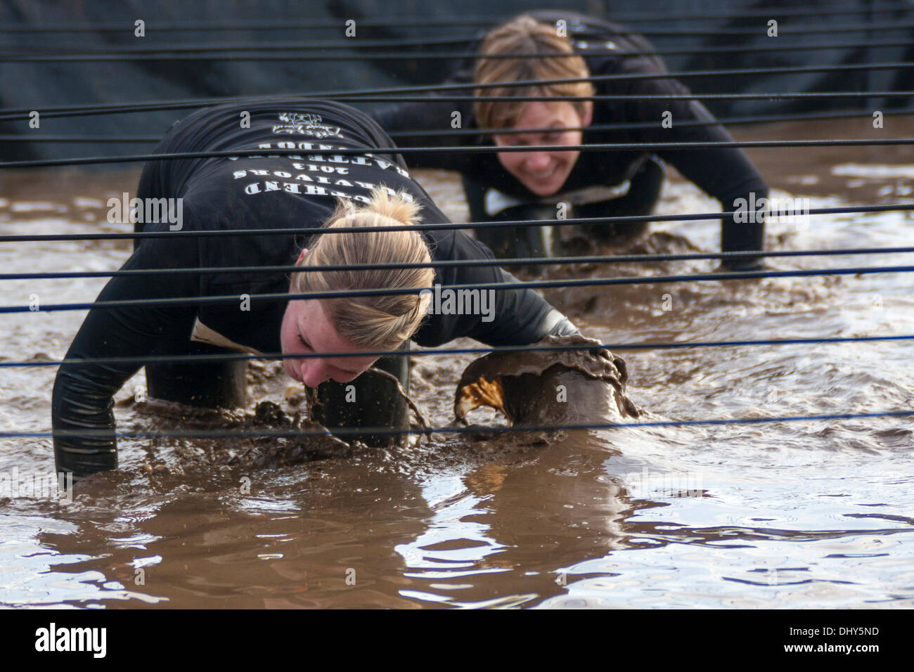 Battersea, Londres, Royaume-Uni. 16 novembre 2013. Les concurrents de ramper dans la boue à la santé masculine la survie du plus fort de l'événement 2013 à Battersea Power Station. Crédit : Paul Davey/Alamy Live News Banque D'Images