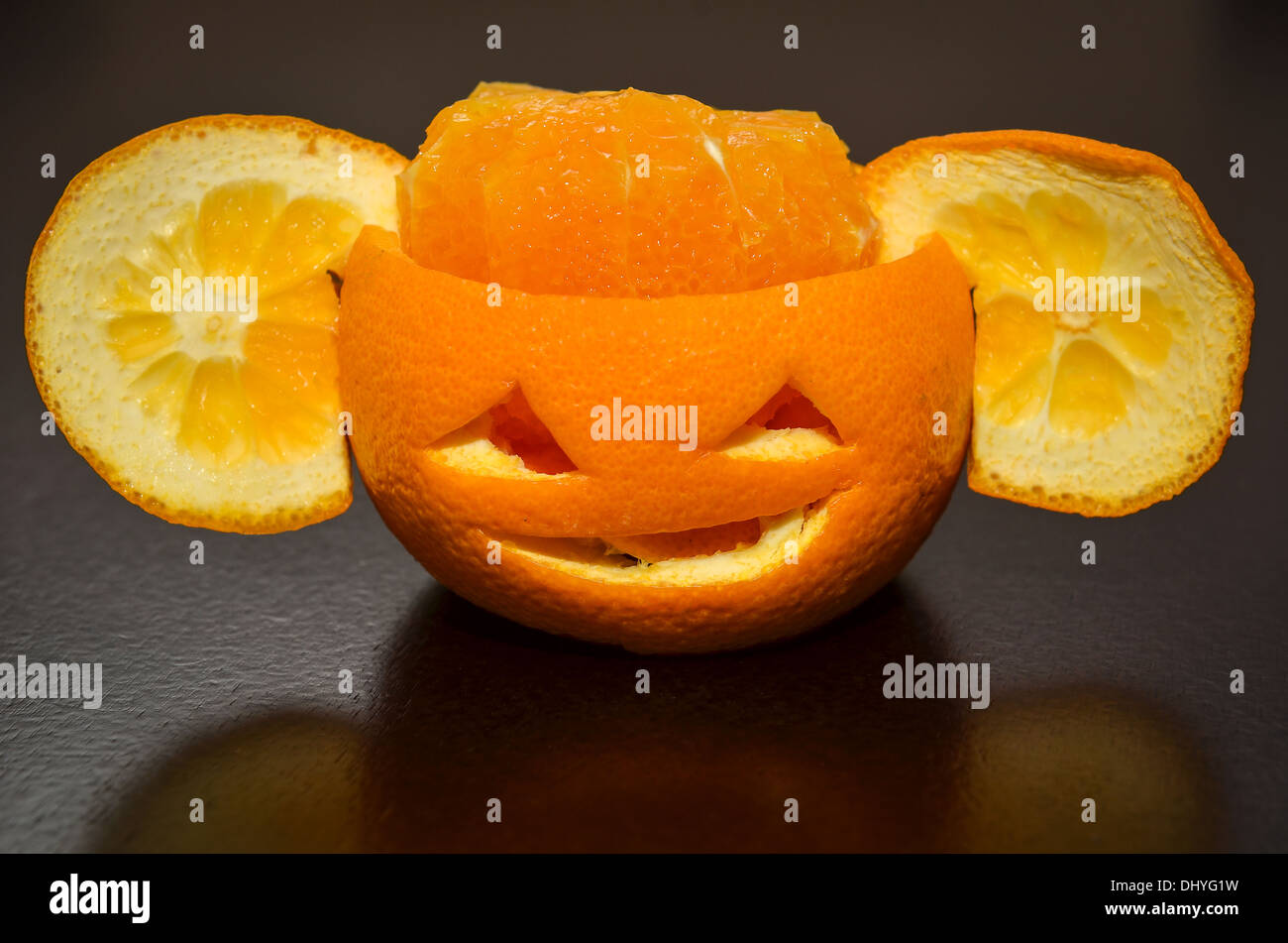 Les agrumes Fruits Orange comme une citrouille sculptée face avec oreilles Banque D'Images
