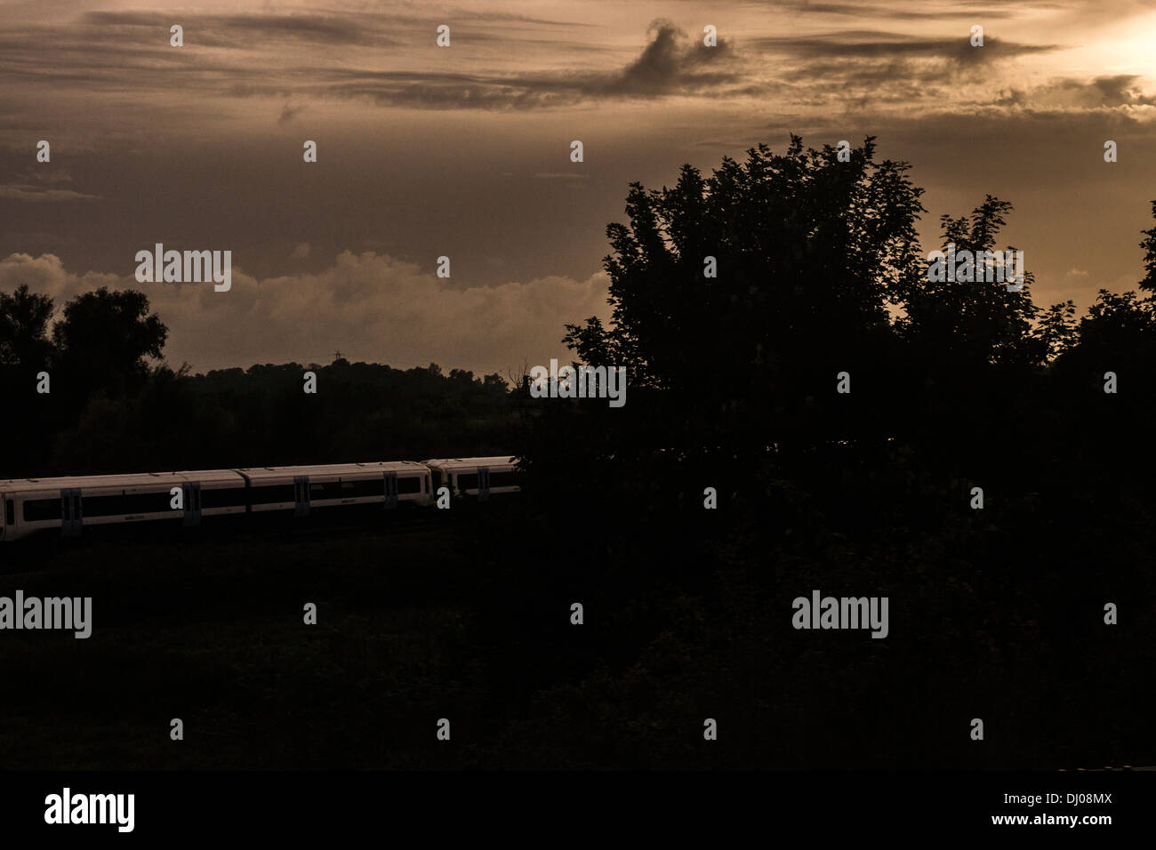 Train d'automne coucher de soleil arbres ciel nuageux nuages de tempête Banque D'Images