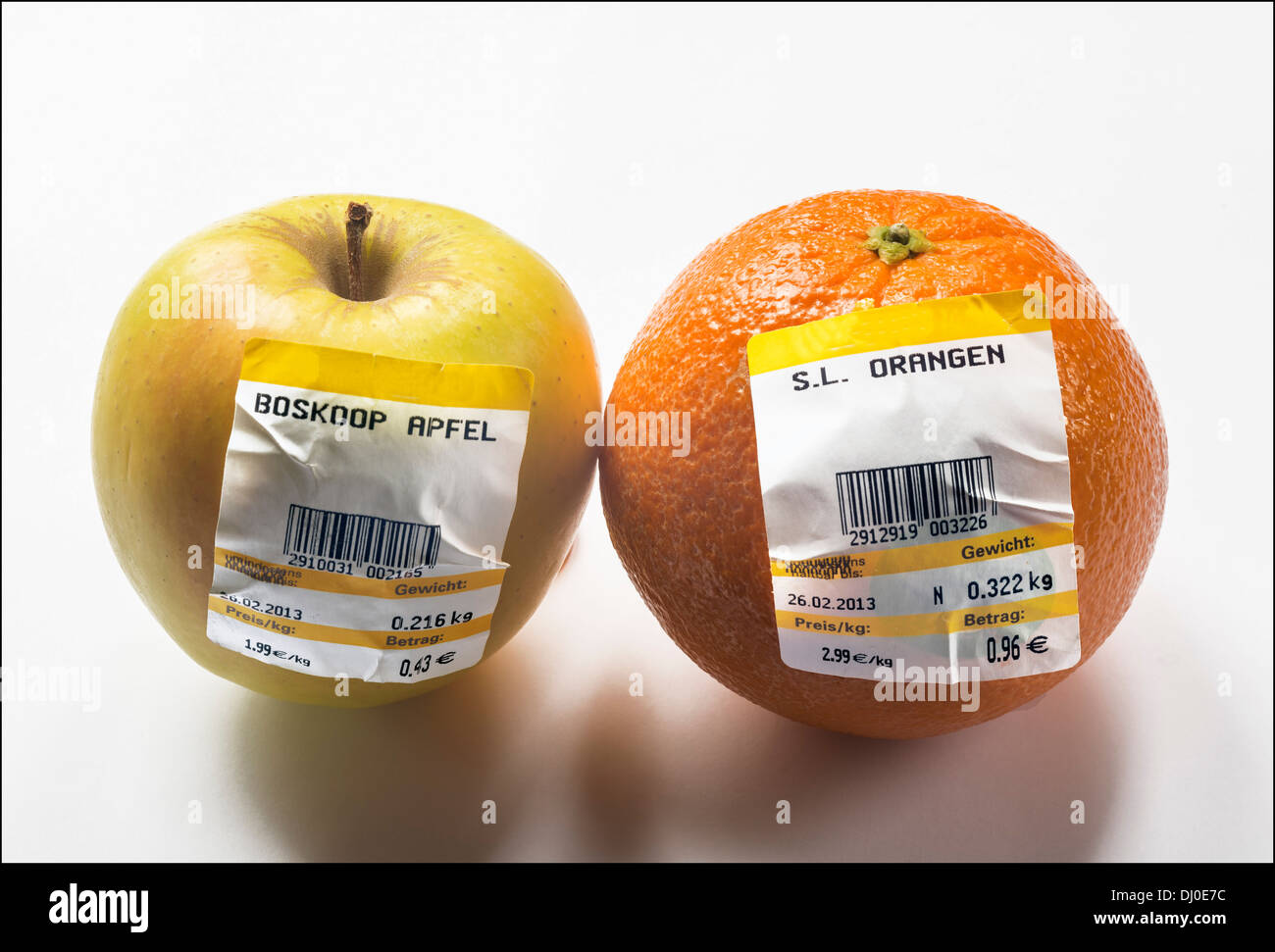 Belle de Boskoop pomme et orange avec l'Allemand des étiquettes à code à barres montrant le poids et prix en Euro Banque D'Images