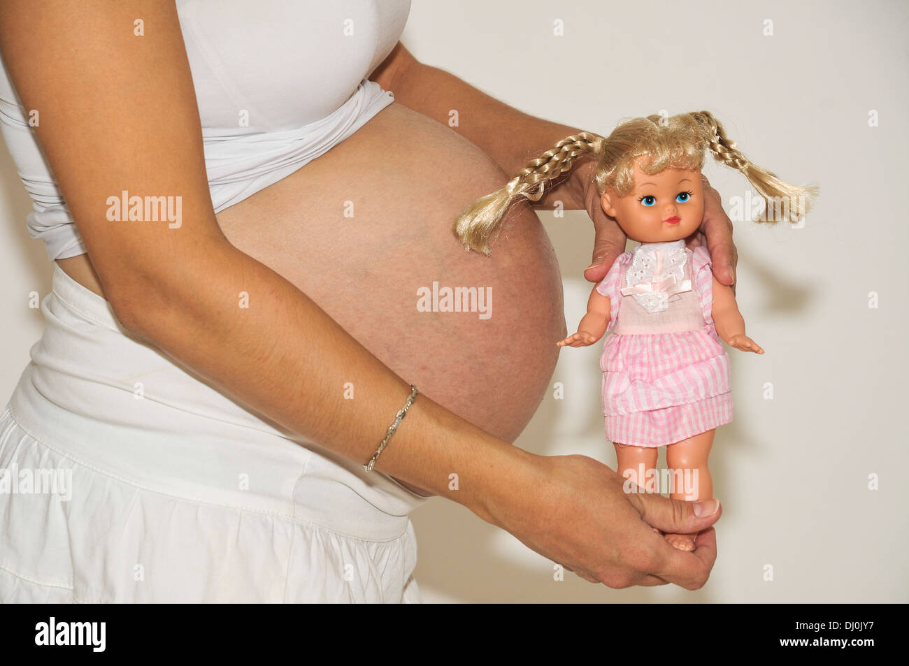 Femme, neuvième mois de grossesse avec poupée sur ventre Autorisation Modèle disponible Banque D'Images