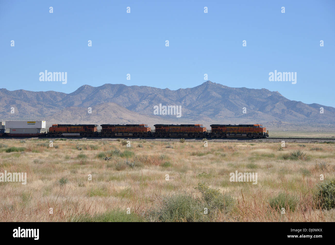 American énorme de multiples unités de train de fret avec 4 locomotives côté s'étend le long de la vieille Route 66, Arizona montagnes au loin Banque D'Images