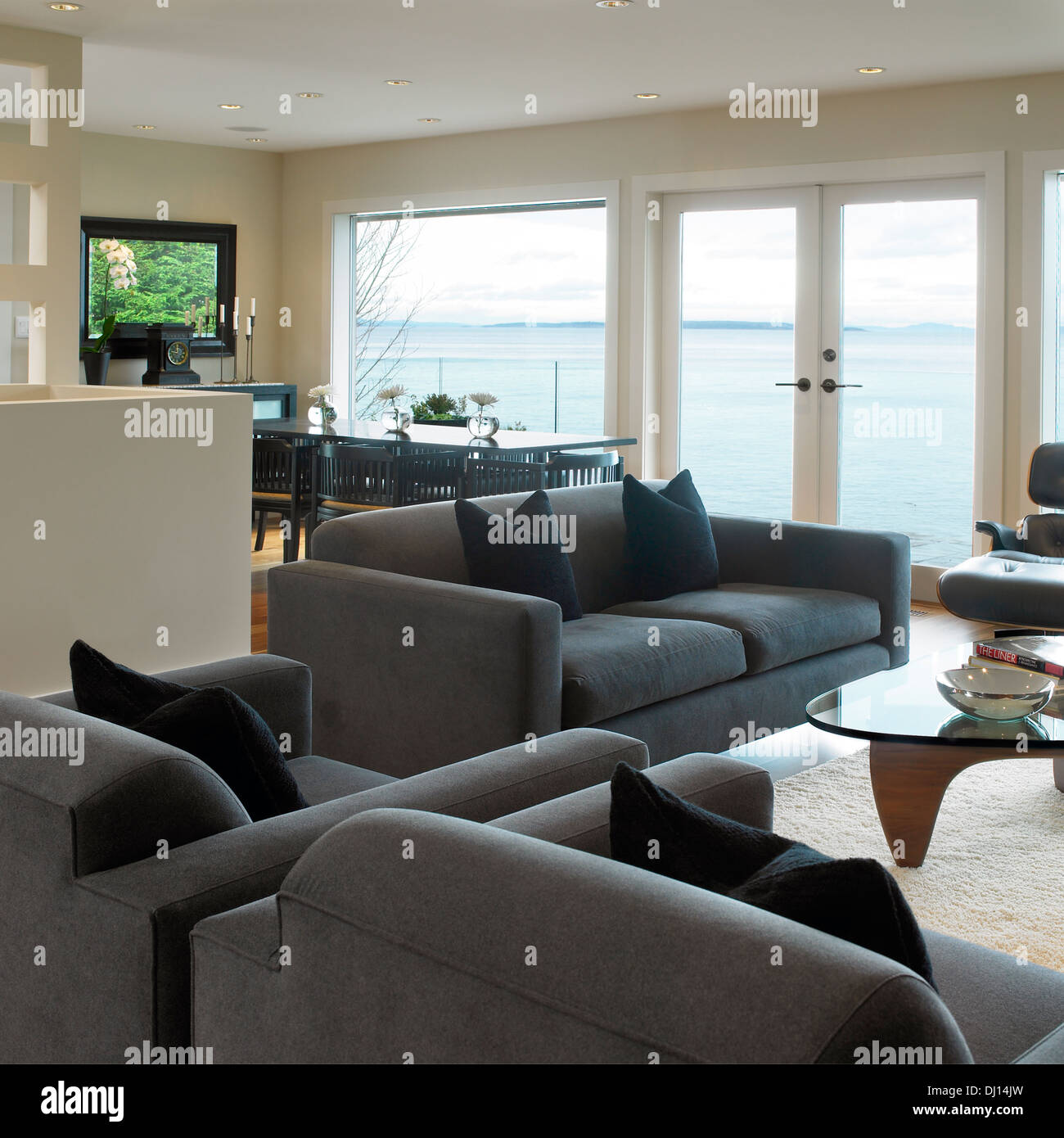 Salle de séjour/salle à manger avec vue sur l'océan et des meubles gris Banque D'Images