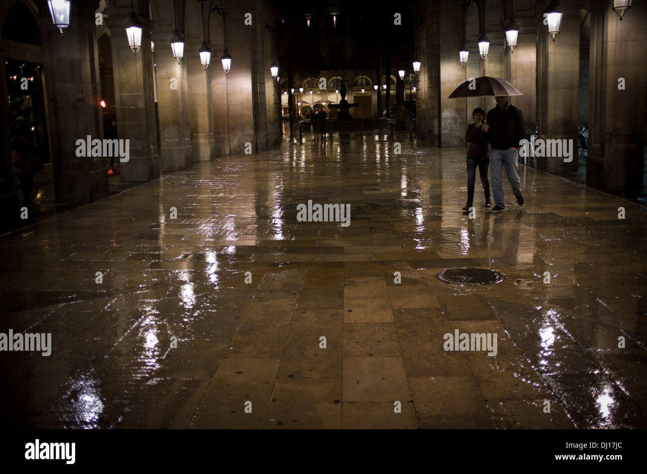 Quartier Gothique de Barcelone, Espagne 18 novembre, 2013.Un couple s'abriter sous un parapluie dans la rue menant de la Rambla à la Place Real à Barcelone. La pluie persistante sur Barcelone après des mois sans pluie. Crédit : Jordi Boixareu/Alamy Live News Banque D'Images