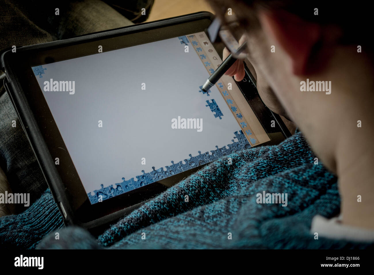 Homme jouant un jeu de puzzle sur un iPad Banque D'Images