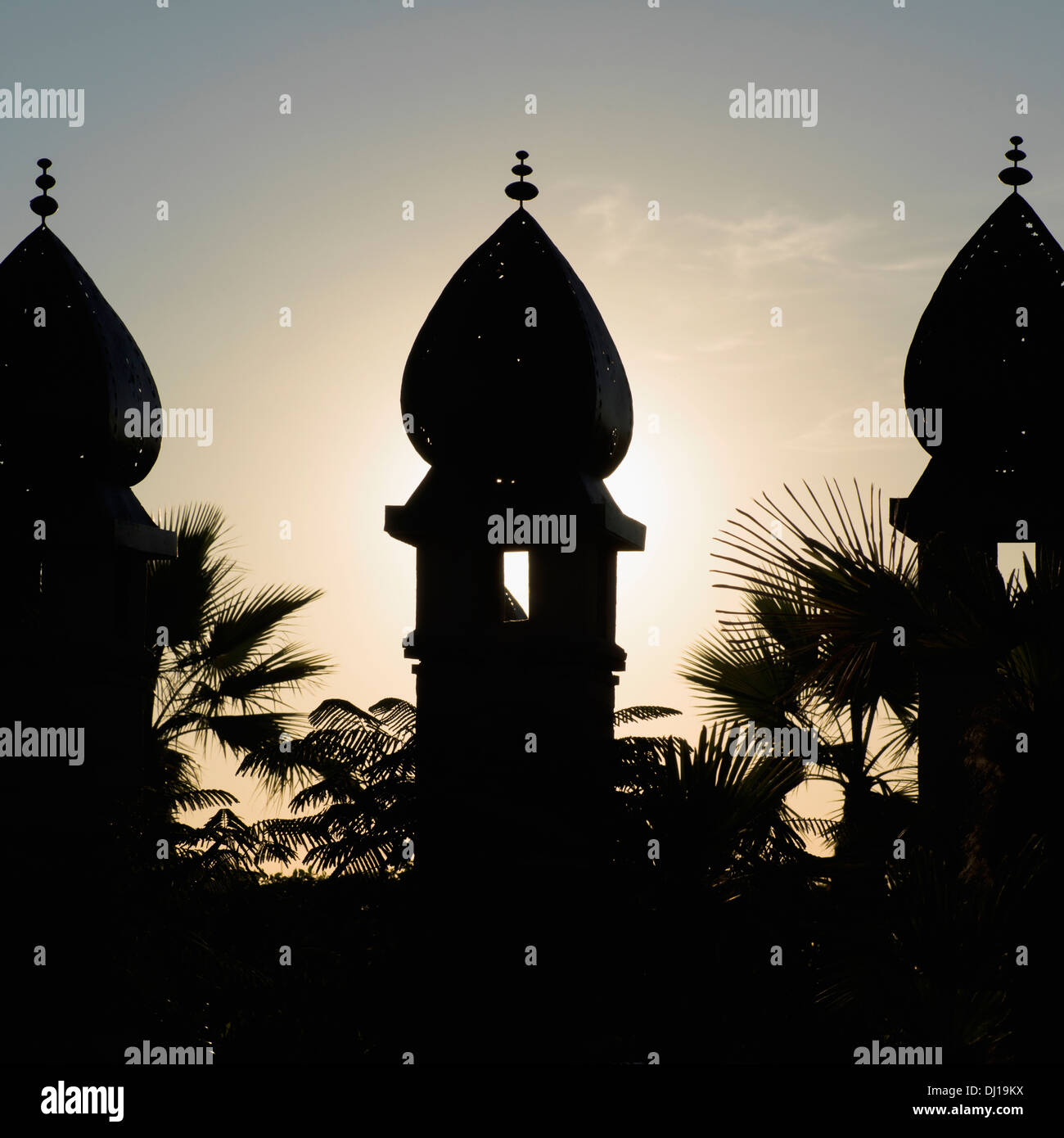 Silhouette de trois tourelles et de palmiers au coucher du soleil Banque D'Images