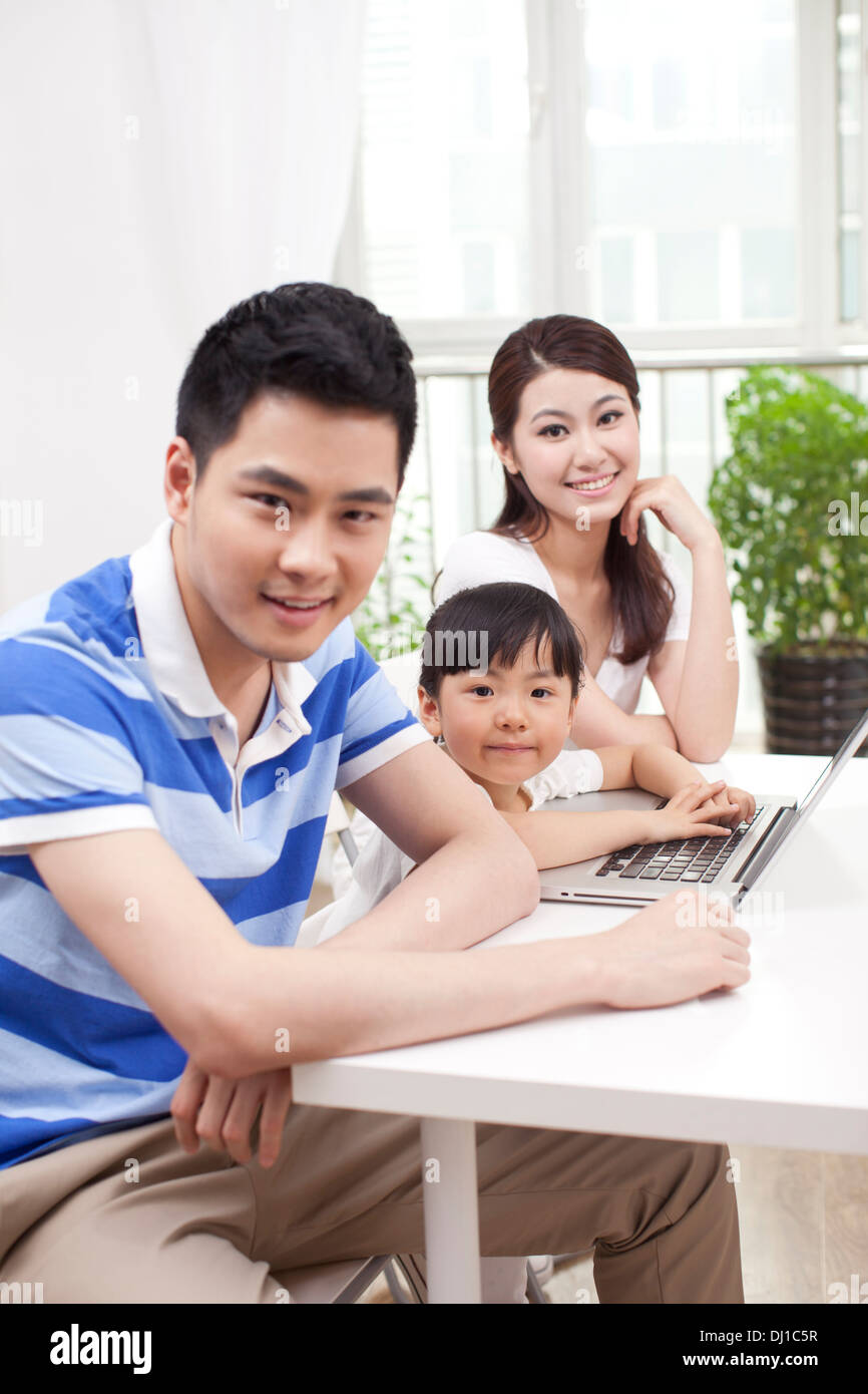 Famille de trois using laptop Banque D'Images