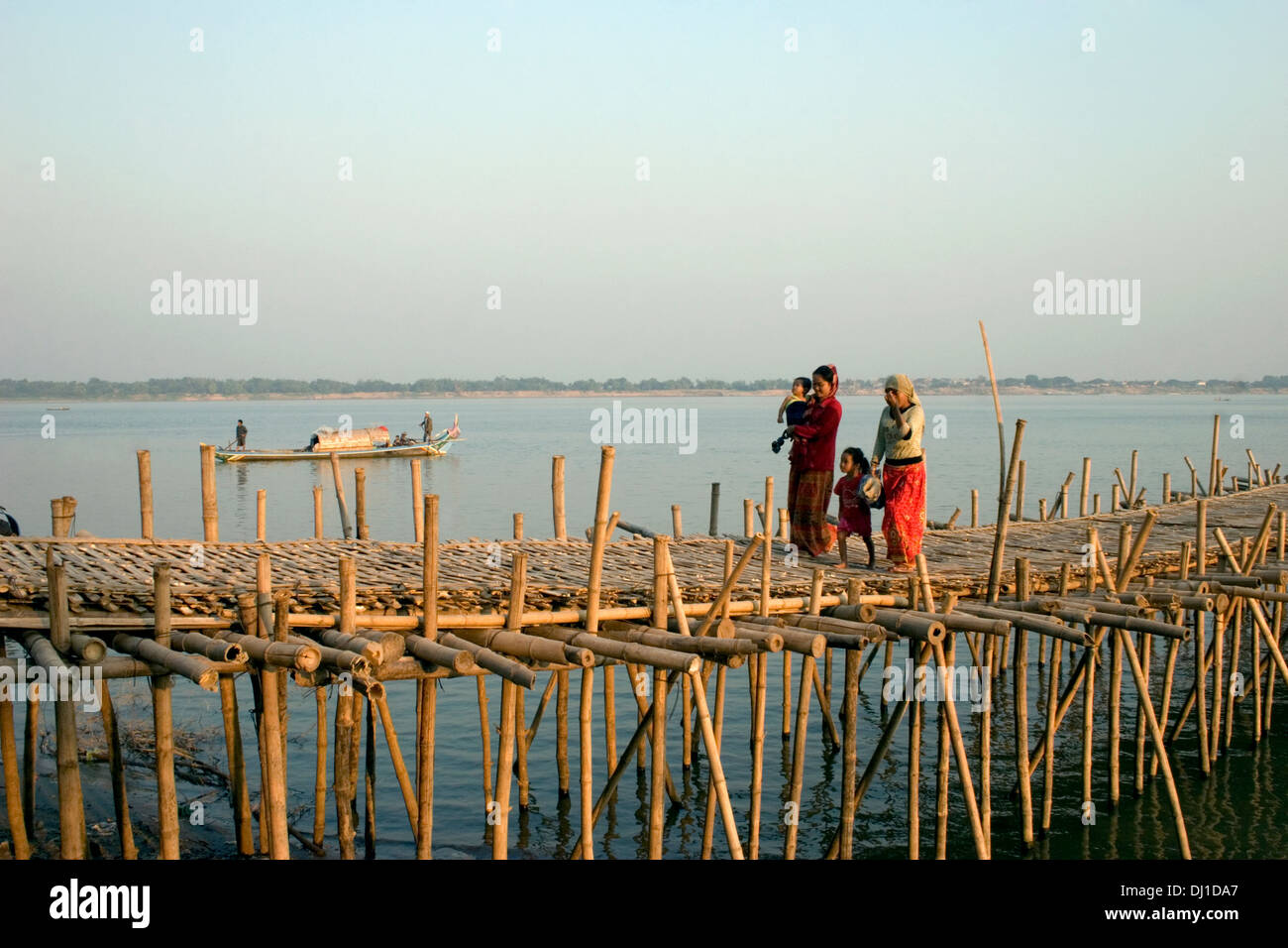 Deux femmes musulmanes et deux enfants marchent sur un pont de bambou sur la rivière du Mékong à Kampong Cham, au Cambodge. Banque D'Images