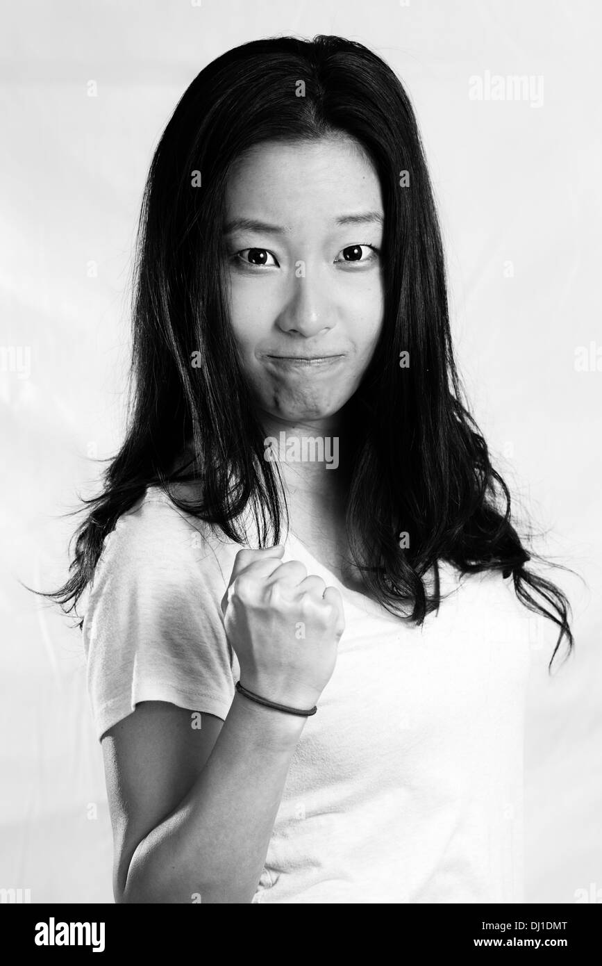 Portrait of attractive young woman serrant son poing d'encouragement, de style noir et blanc Banque D'Images