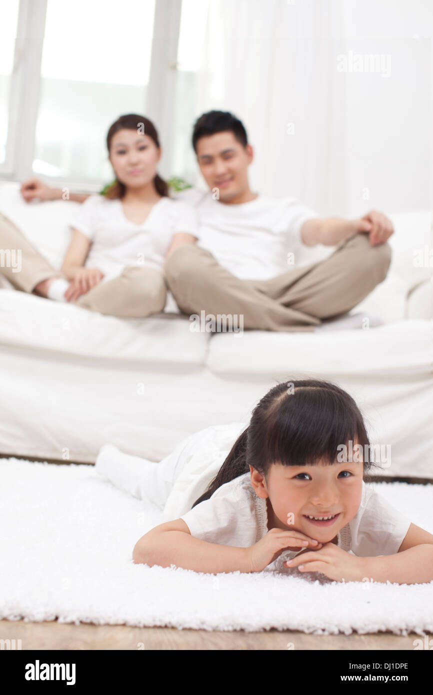 Jeune fille chinoise dans un salon avec les parents dans l'arrière-plan Banque D'Images