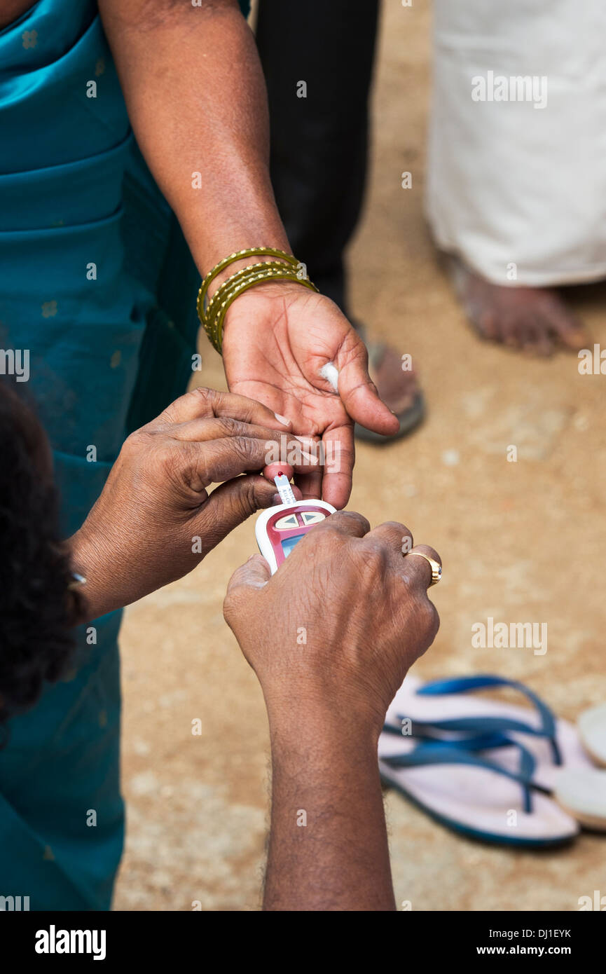 Des tests de glycémie un patient diabétique à Sri Sathya Sai Baba mobiles de proximité hôpital clinique. L'Andhra Pradesh, Inde. Banque D'Images