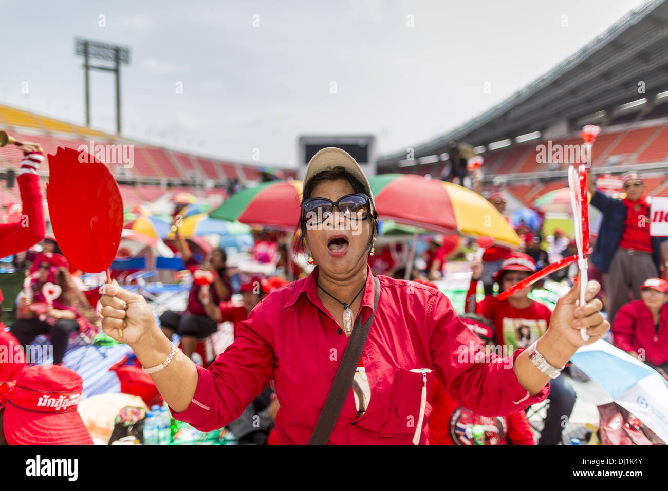 Bangkok, Thaïlande. 19 nov., 2013. Chemise rouge manifestants cheer pour haut-parleurs pendant un rassemblement. Jusqu'à 30 000 sont attendus à Bangkok cette semaine à l'avance d'une décision de la cour thaïlandaise qui pouvait entraîner la chute du gouvernement. Les chemises rouges sont réunis dans un stade de banlieue avant de marcher à la cour et consistent essentiellement d'agriculteurs et ruraux thaïlandais qui appuient le gouvernement Shinawatra. © Jack Kurtz/ZUMAPRESS.com/Alamy Live News Banque D'Images