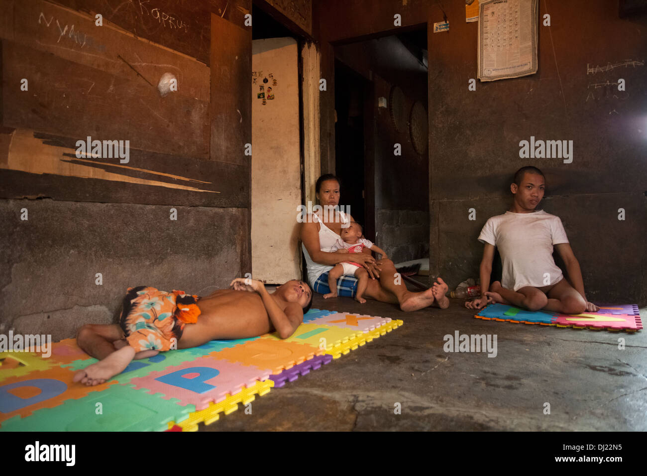 Famille pauvre estropié a contesté l'homme la lutte contre la pauvreté extrême de Bali Indonésie 29 standard ci-dessous pauvres conditions dures inhumains sale house Banque D'Images