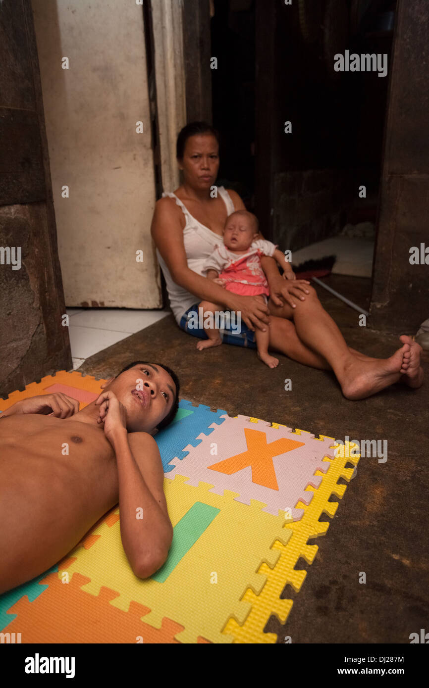 Famille pauvre estropié a contesté l'homme la lutte contre la pauvreté extrême de Bali Indonésie 29 standard ci-dessous pauvres conditions dures inhumains sale house Banque D'Images