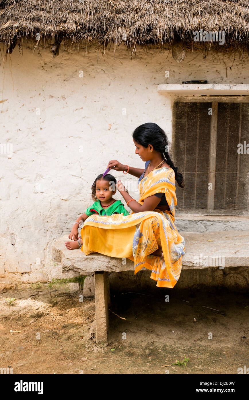 Mère indienne peignant ses cheveux de jeunes filles dans un village de l'Inde rurale. L'Andhra Pradesh, Inde Banque D'Images