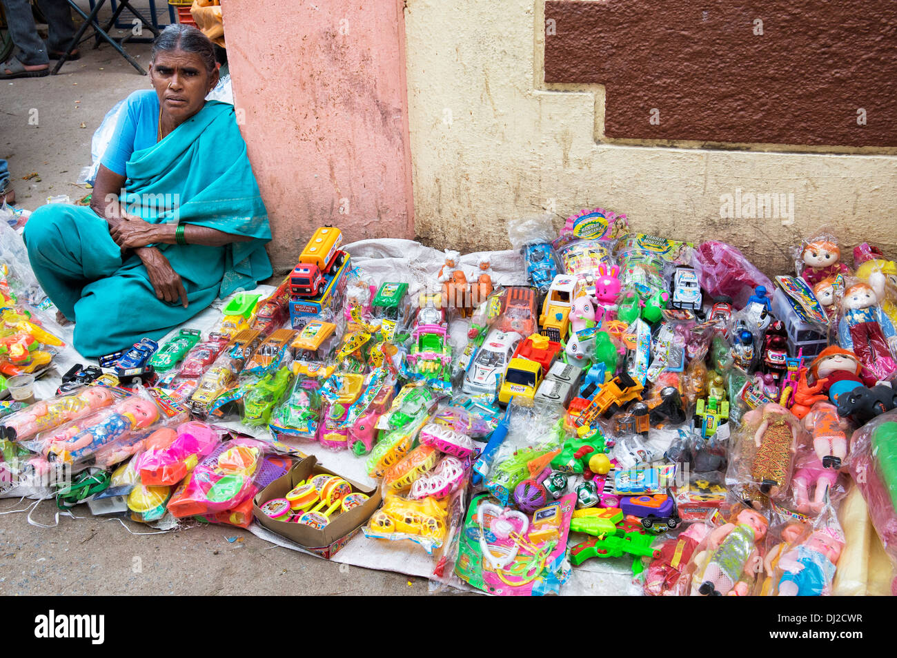 Femme indienne la vente de jouets en plastique bon marché à un marché indien. L'Andhra Pradesh, Inde Banque D'Images