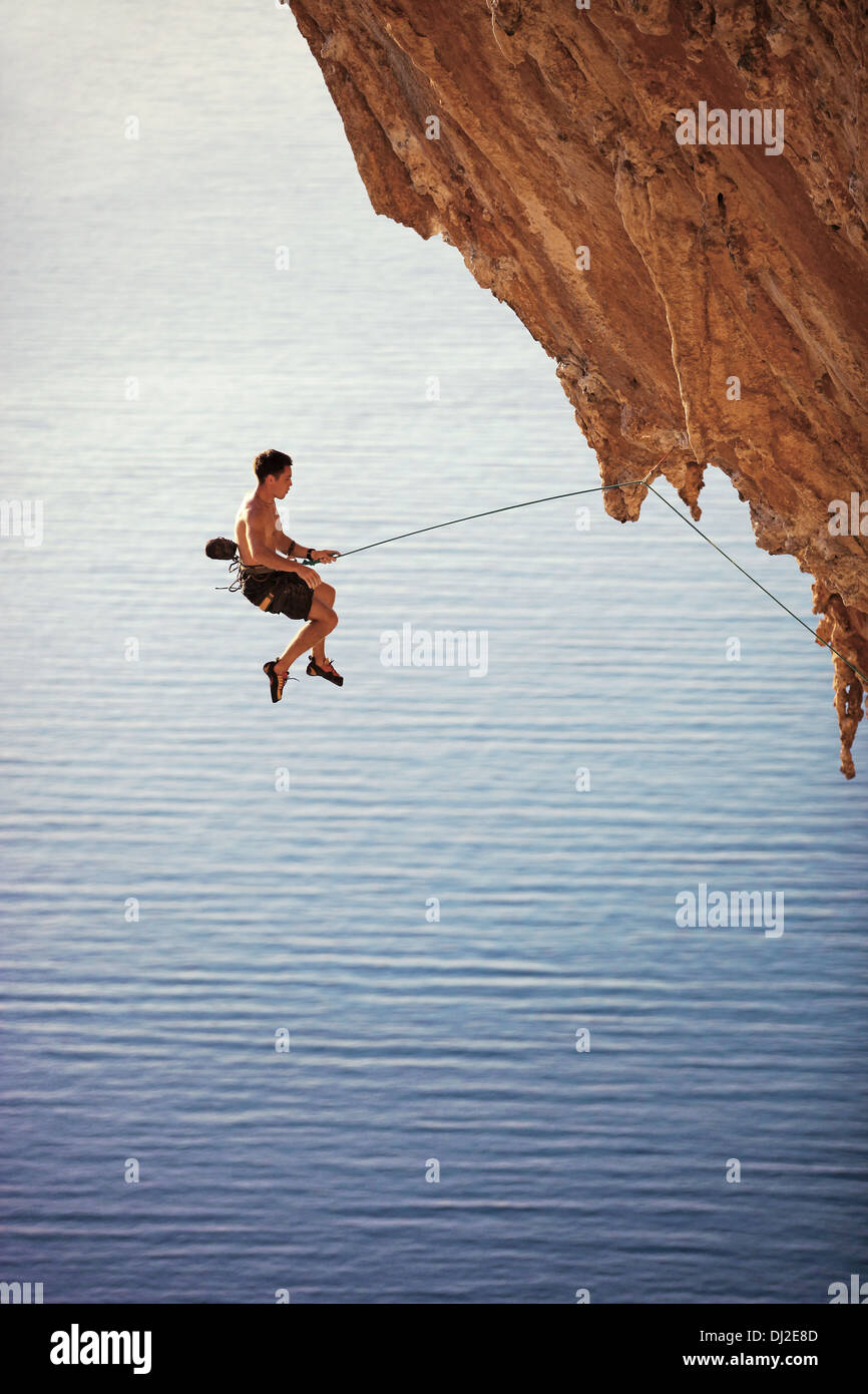 Rock climber tomber d'une falaise tout en escalade Banque D'Images