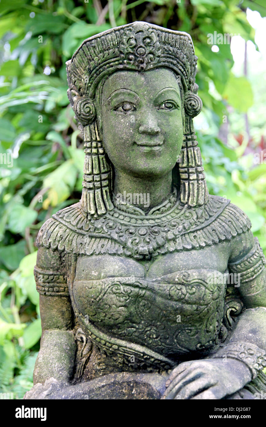 Ancienne statue de femme dans le jardin et regarder son sourire un peu. Banque D'Images
