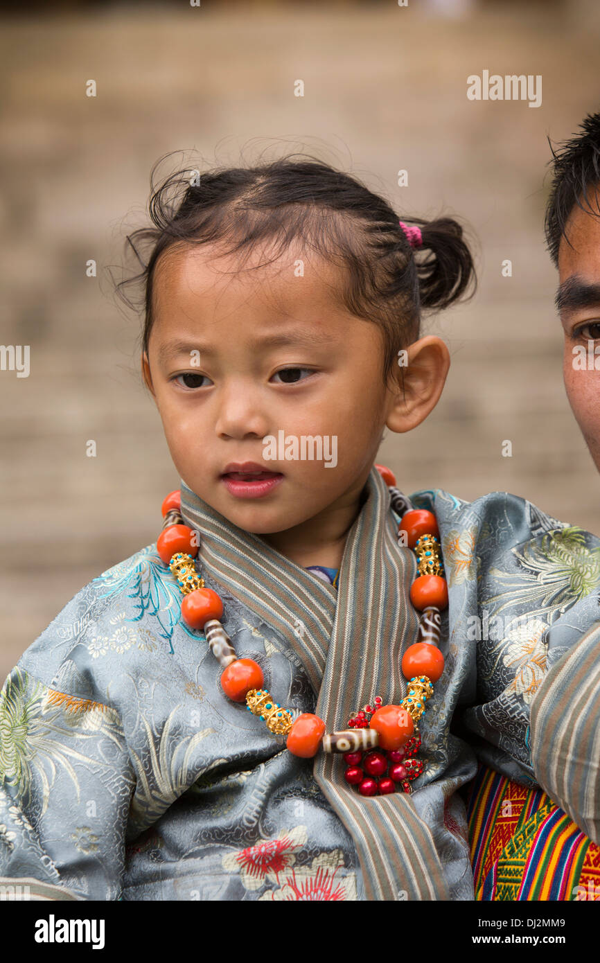 Le Bhoutan, Thimphu Dzong, Tsechu annuel, traditionnellement vêtus jeune fille dans les bras du père Banque D'Images