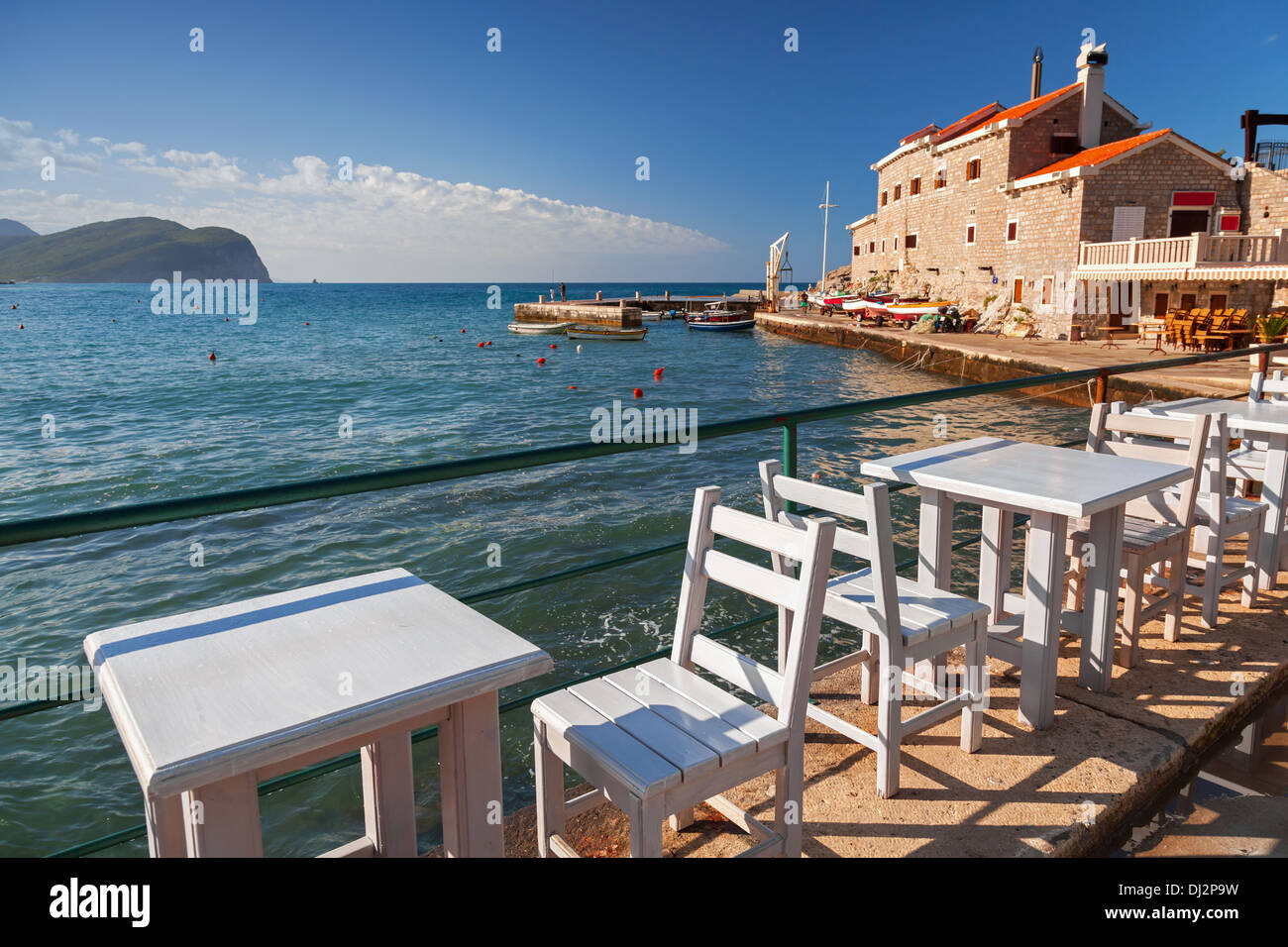 Chaises et tables en bois blanc, position sur la côte de la mer Adriatique à Petrovac, Monténégro Banque D'Images