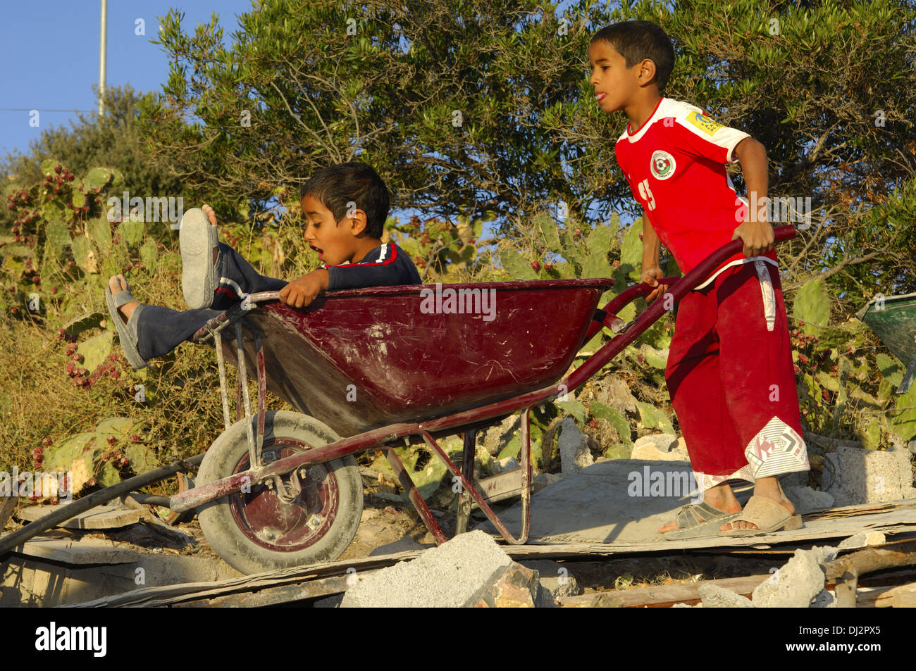Deux garçons omanaises jouant avec une brouette Banque D'Images