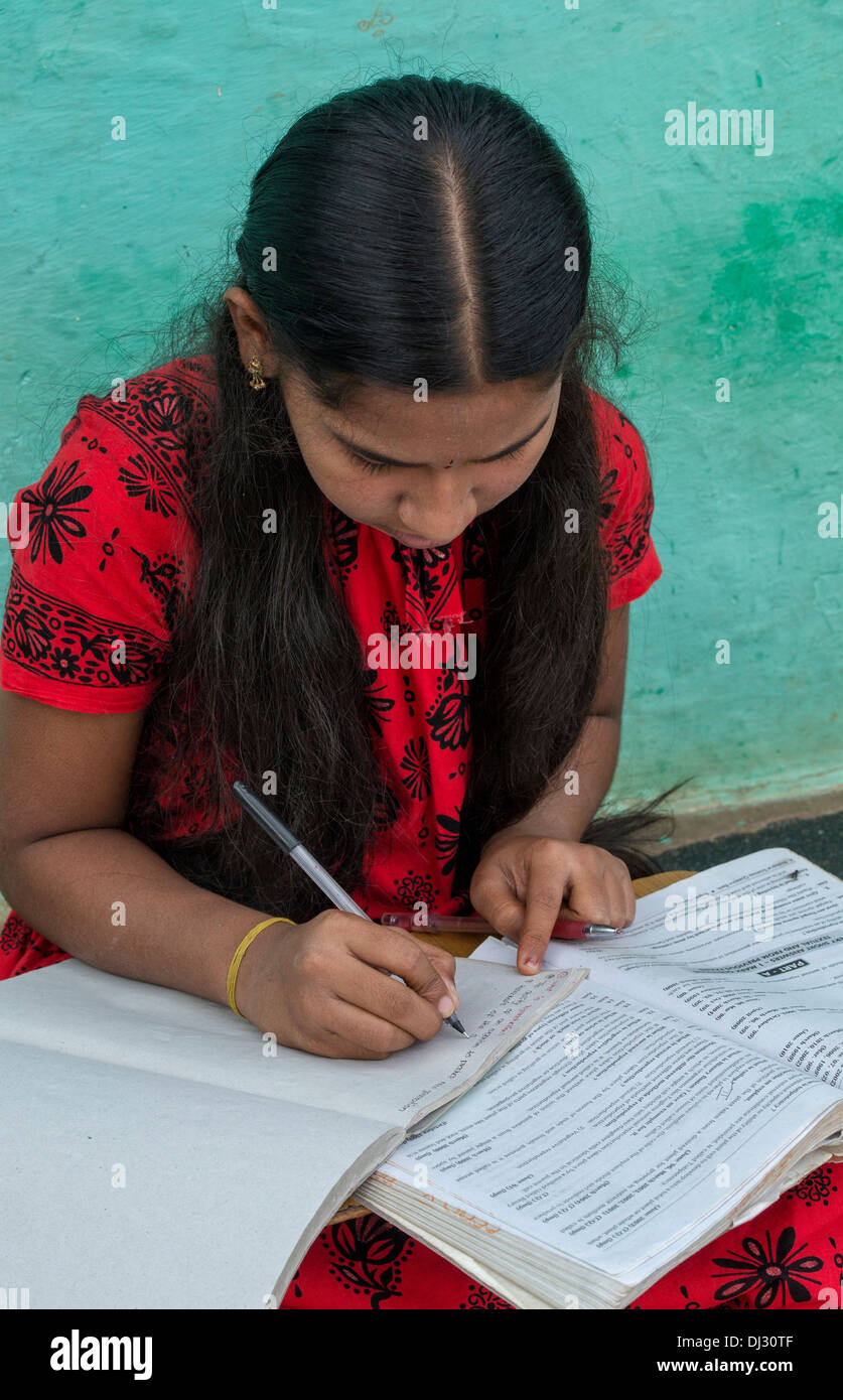 Village indien Teenage girl écrit l'anglais à l'école livre. L'Andhra Pradesh, Inde Banque D'Images