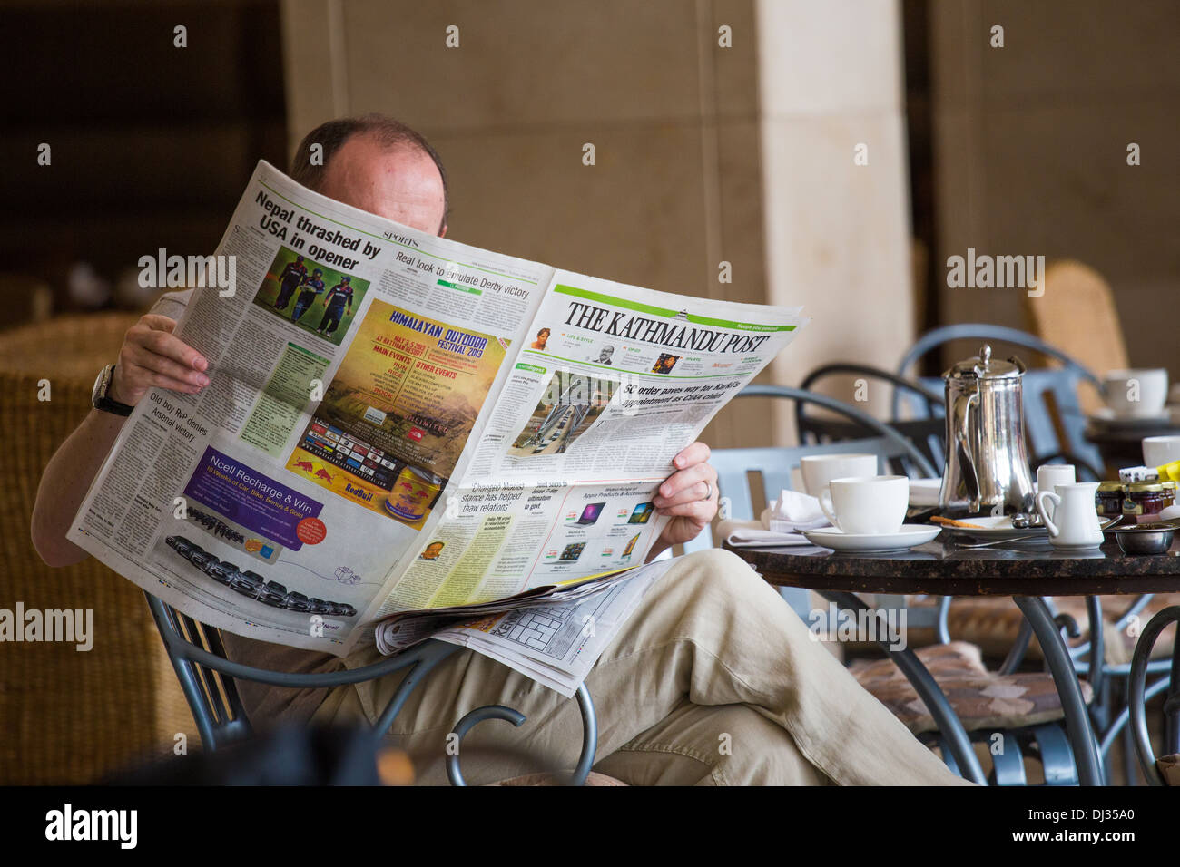 Visiteur étranger lire le Kathmandu Post newspaper au Hyatt, Katmandou, Népal Banque D'Images