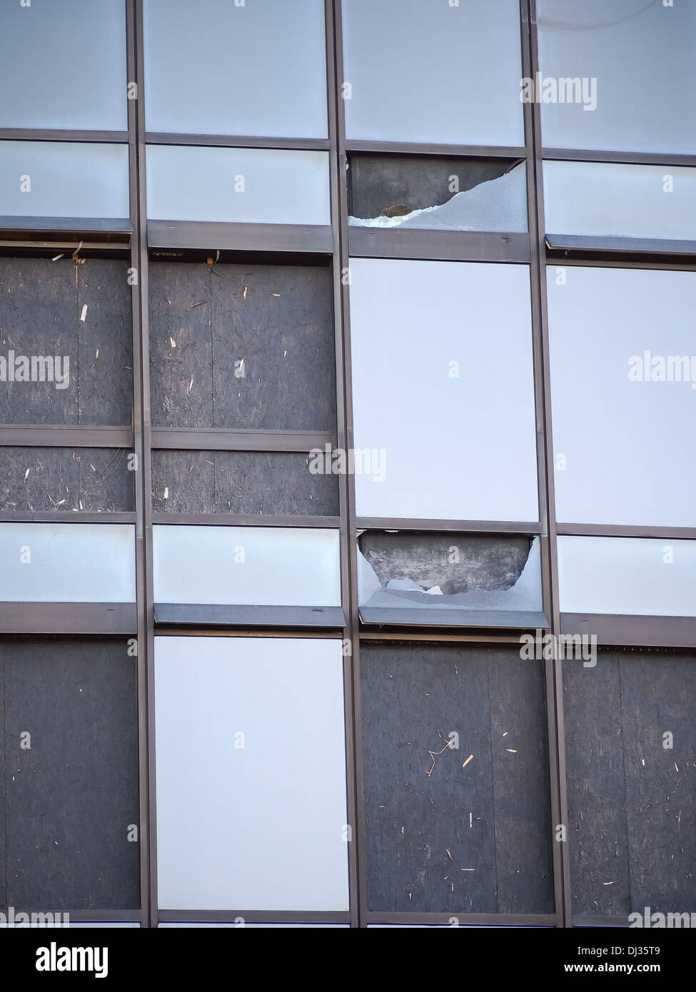 Brisé et barricadèrent windows dans un immeuble de bureaux en verre Banque D'Images