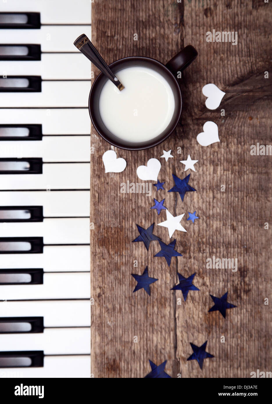 Image tonique, tasse de lait sur la table en bois, cuillère, Étoiles et coeurs en papier, pianoforte Banque D'Images