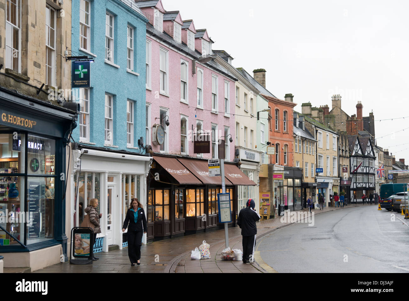 Immeubles et commerces dans la rue principale à Cirencester ROYAUME UNI le jour pluvieux Banque D'Images