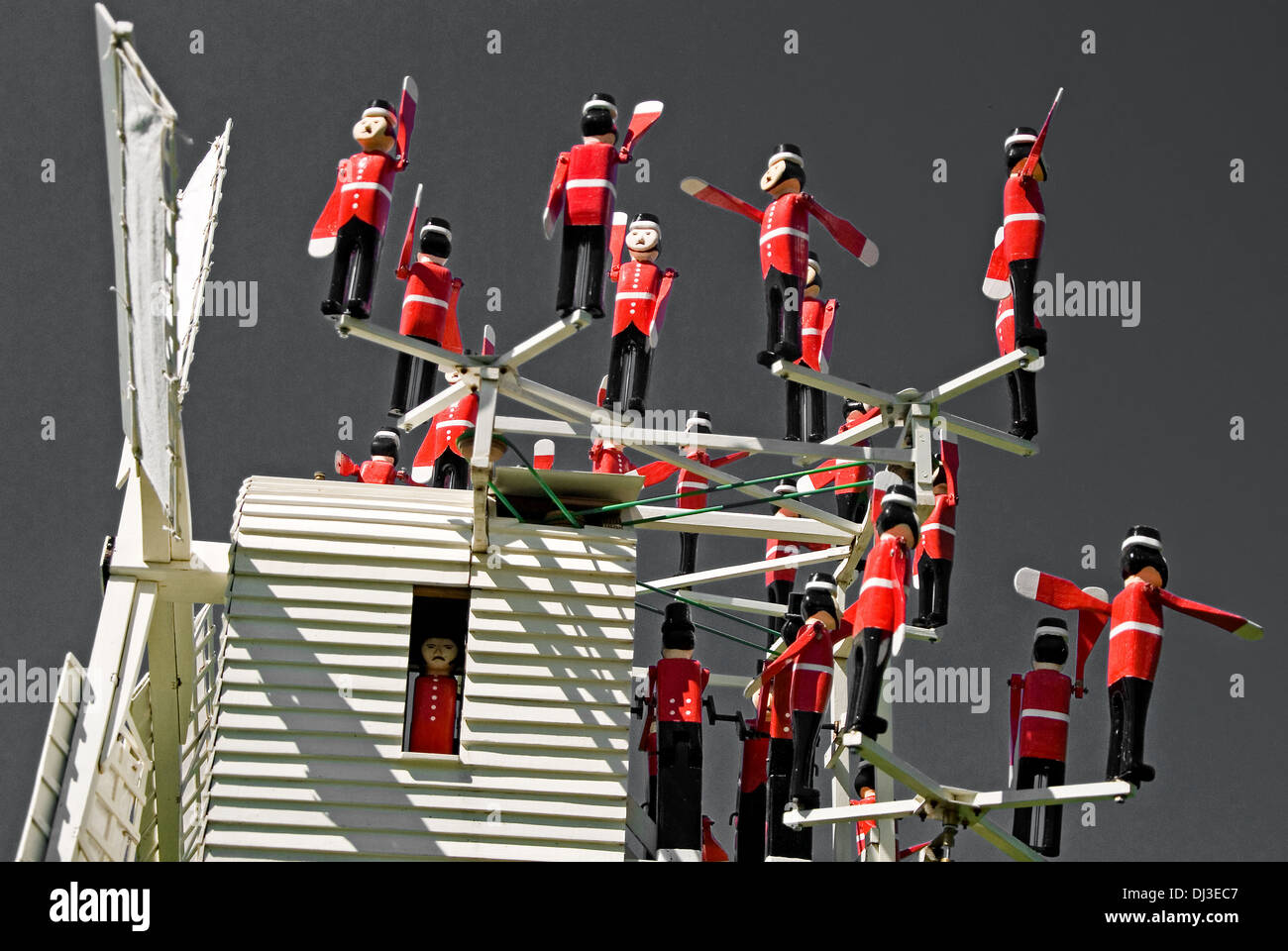 Une image monochrome d'une girouette unique en uniforme rouge avec des petits soldats. Banque D'Images