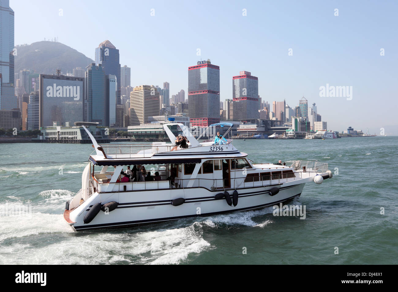 Yacht à moteur avec les touristes en croisière dans le port de Hong Kong Banque D'Images