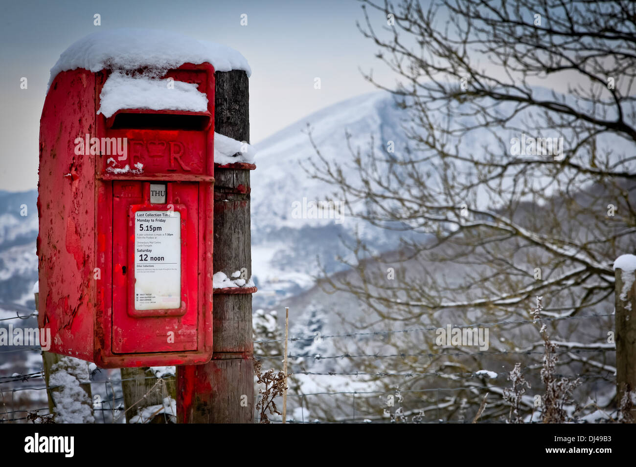 Un brillant rouge Royal Mail postbox couvertes de neige dans le Shropshire Hills Banque D'Images