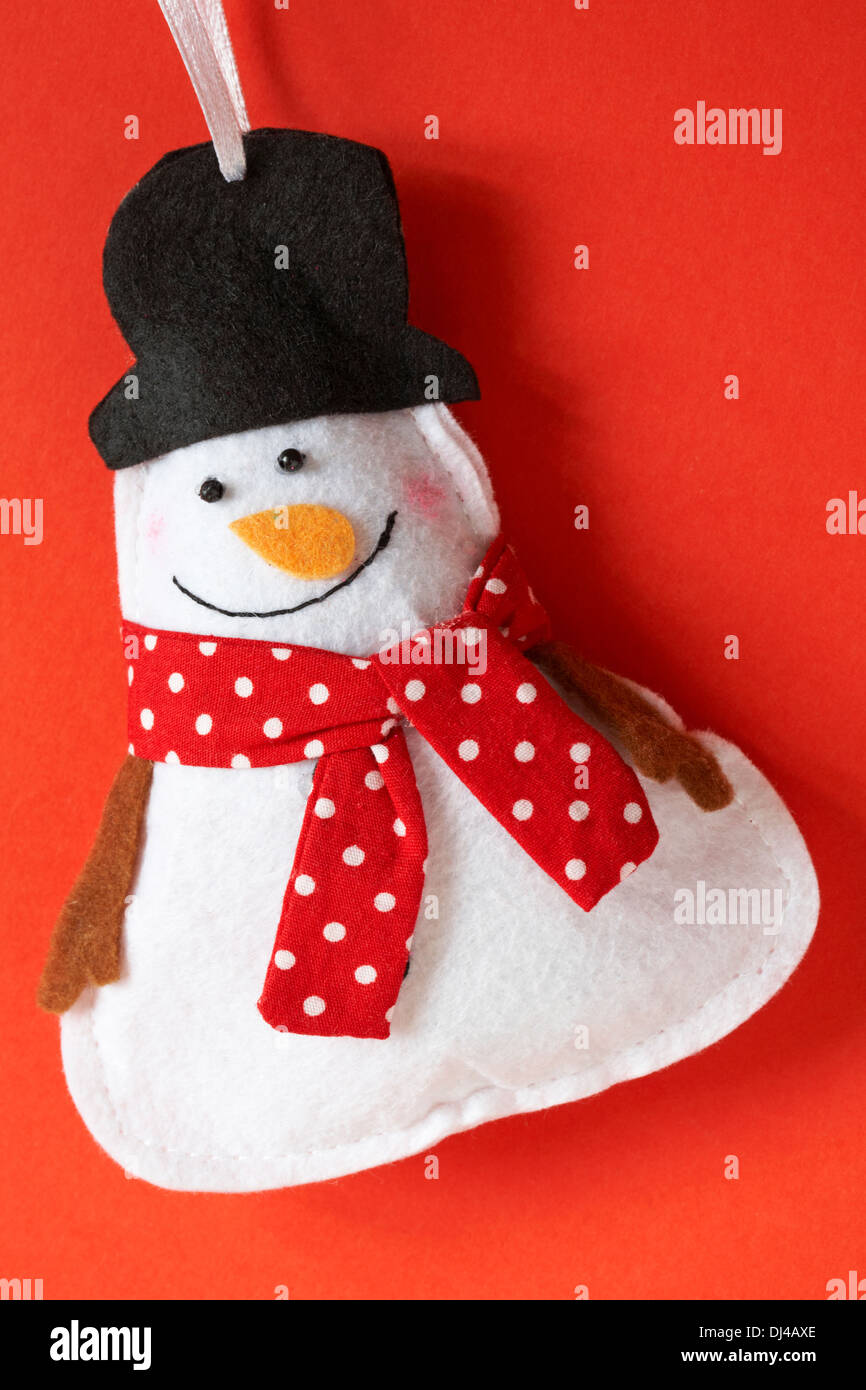 Le Snowman wearing foulard rouge à pois noir et top hat decoration prêt pour Noël sur fond rouge Banque D'Images