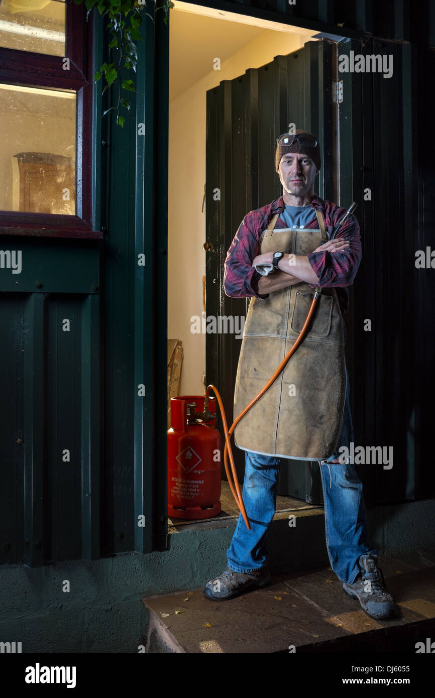 Artisan à l'extérieur de son atelier. Banque D'Images